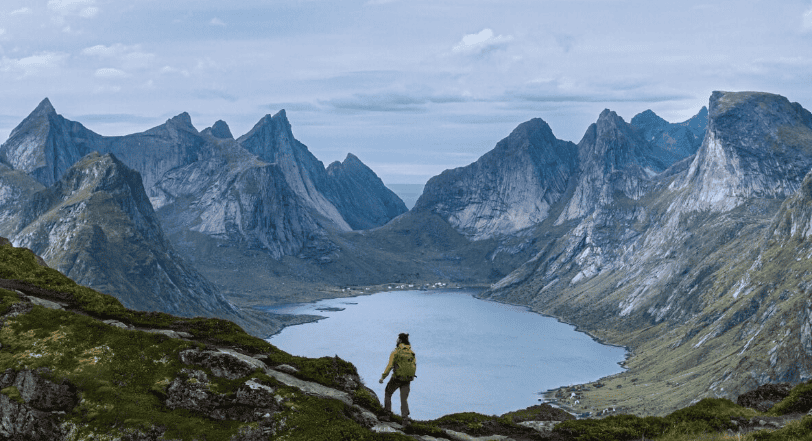 תמונה של נוף הרים ועמק עם אגם במרכז, במזג אוויר מעונן.